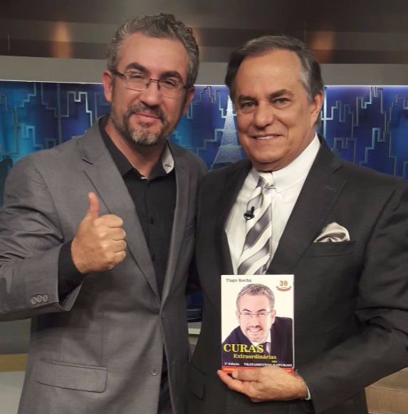 Artista com o livro Curas Extraordinárias